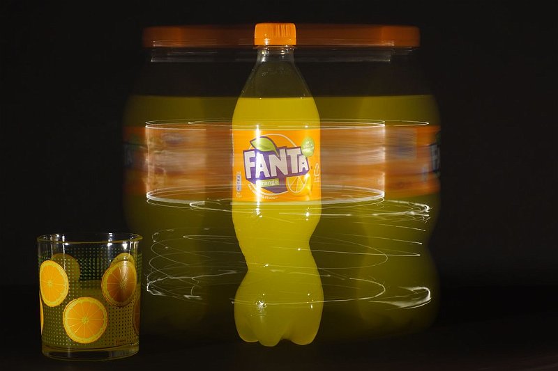 AH01.JPG - Bij deze opname met een lange belichtingstijd heeft  gedurende ongeveer de helft van de tijd het flesje fanta stil gestaan en de andere helft heeft hij rond gedraaid. Het glas stond naast de draaischijf waardoor dit is stil blijven staan.