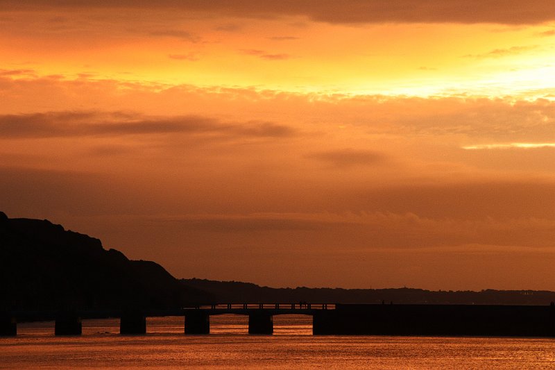 AA01.JPG - Sfeervol deze foto van de brug bij ondergaande zon. Goede doortekening van de lucht en het water. Dieptewerking doordat het donkerder van de brug met "kade?" afsteekt bij het iets minder donker van het landschap erachter. Mooie compositie. 