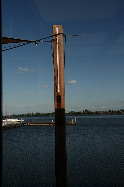 AD02.JPG - De paal half verlicht, de blauwe hemel, het licht golvende water, een heerlijke zomerse dag zo te zien. Leuk dat de schaduw op de paal bijna gelijk loopt aan de horizon.